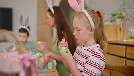 la familia decora el huevo de pascua.