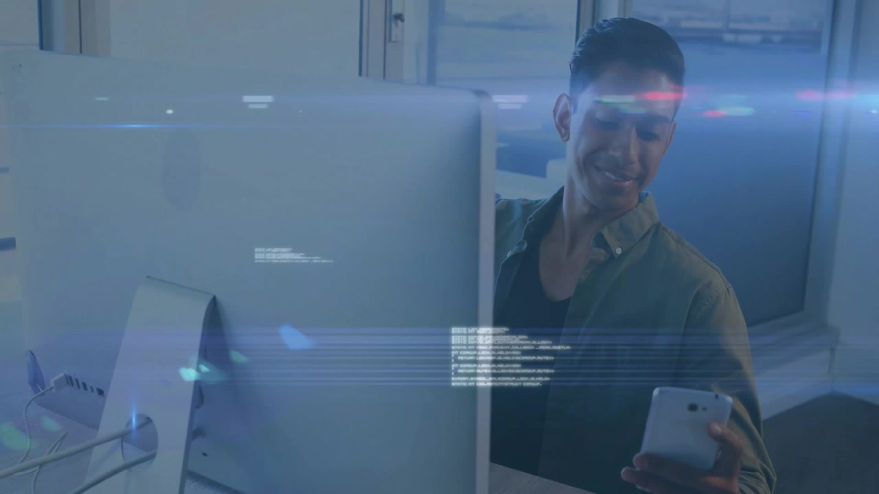Office worker typing then grabbing phone as blue code overlays intensifying, checking tech alerts