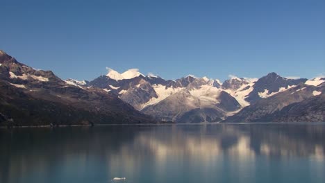 Cruising-in-the-calm-waters-of-Tarr-Inlet-from-Alaska,-Snowy-mountains-in-the-background