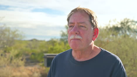 Portrait-of-Caucasian-senior-man-outdoors-taking-off-protective-face-mask,-breathing-deeply-fresh-air