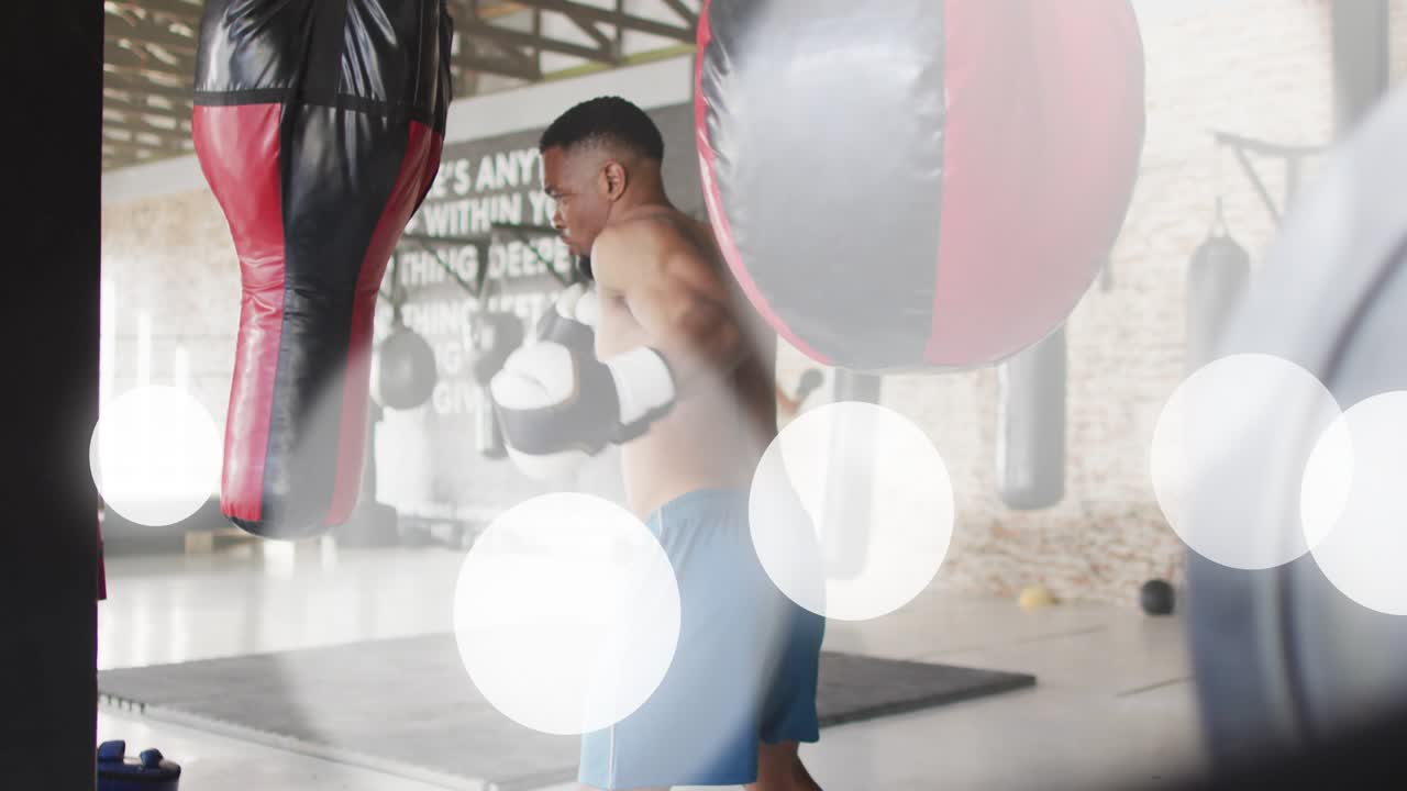Male boxer starting guard and throwing jabs in boxing gym, training power with bokeh flares passing