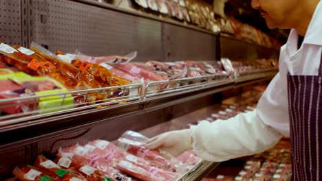 carnicero organizando la carne envuelta en el estante 4k