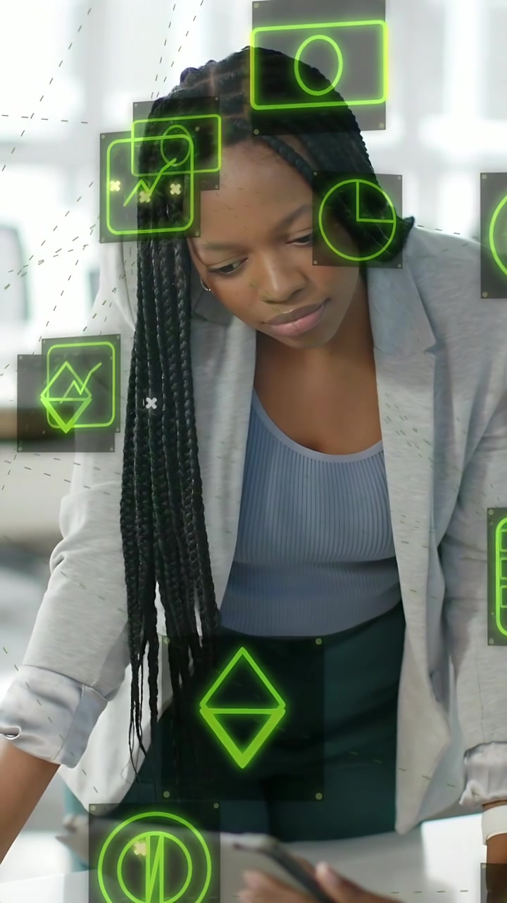 Vertical video: Woman leaning over desk taking tablet from peer reading green UI charts for finance
