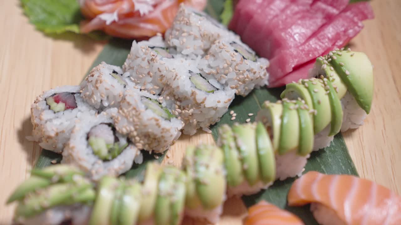 A rising shot showcases a variety of sushi on display, highlighting vibrant colors and intricate presentation. Perfect for culinary, sushi, and food content.