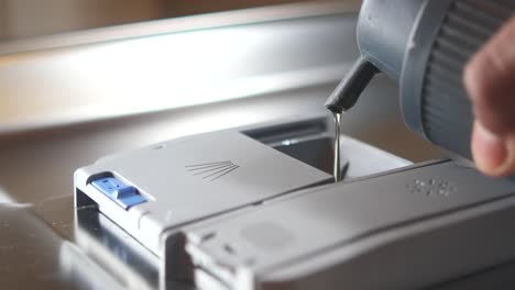 pouring dishwasher detergent into the dispenser