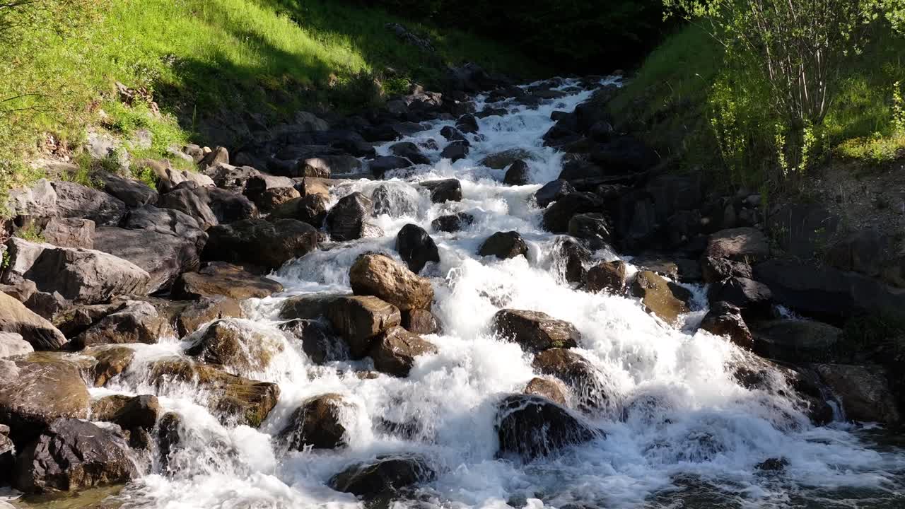 vista en cámara lenta de un río de montaña que fluye sobre rocas y piedras en weesen, suiza, capturando el concepto de dinamismo natural y desierto intacto