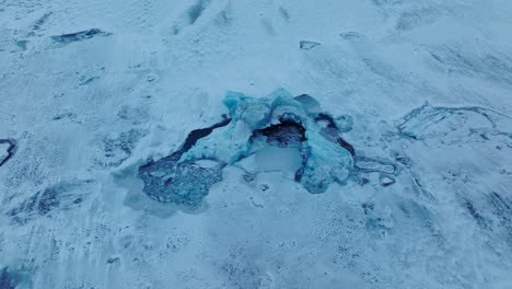 aerial top view over icebergs on the frozen jokulsarlón lake surface, in iceland, at dusk