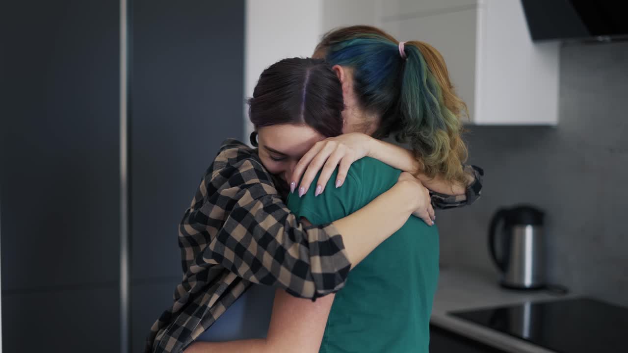 pareja embarazada del mismo sexo bailando en la cocina en casa