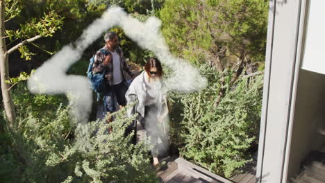 animation of house shape over diverse couple walking in garden