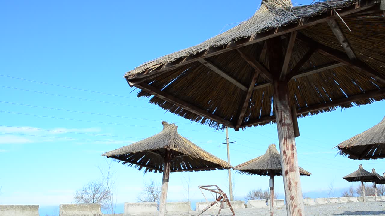Riprese su una spiaggia. Ombrelloni di paglia