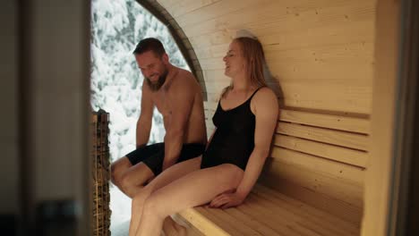 caucasian adult couple enjoying in the sauna in winter.