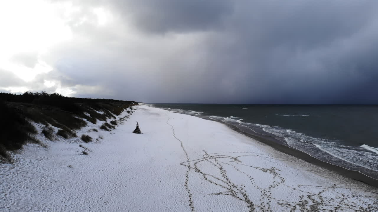 Snowy beach landscape with dramatic clouds