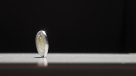 mexican 1 peso coin spinning on table