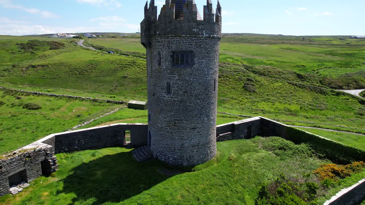 la torre del castillo de piedra de doonagore rodeada de prados de hierba en el condado de clare