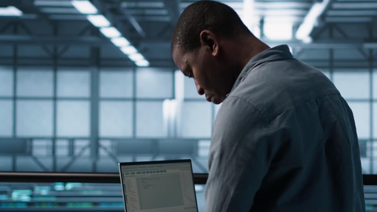 Engineer in data center operating notebook, deploying new server architectures