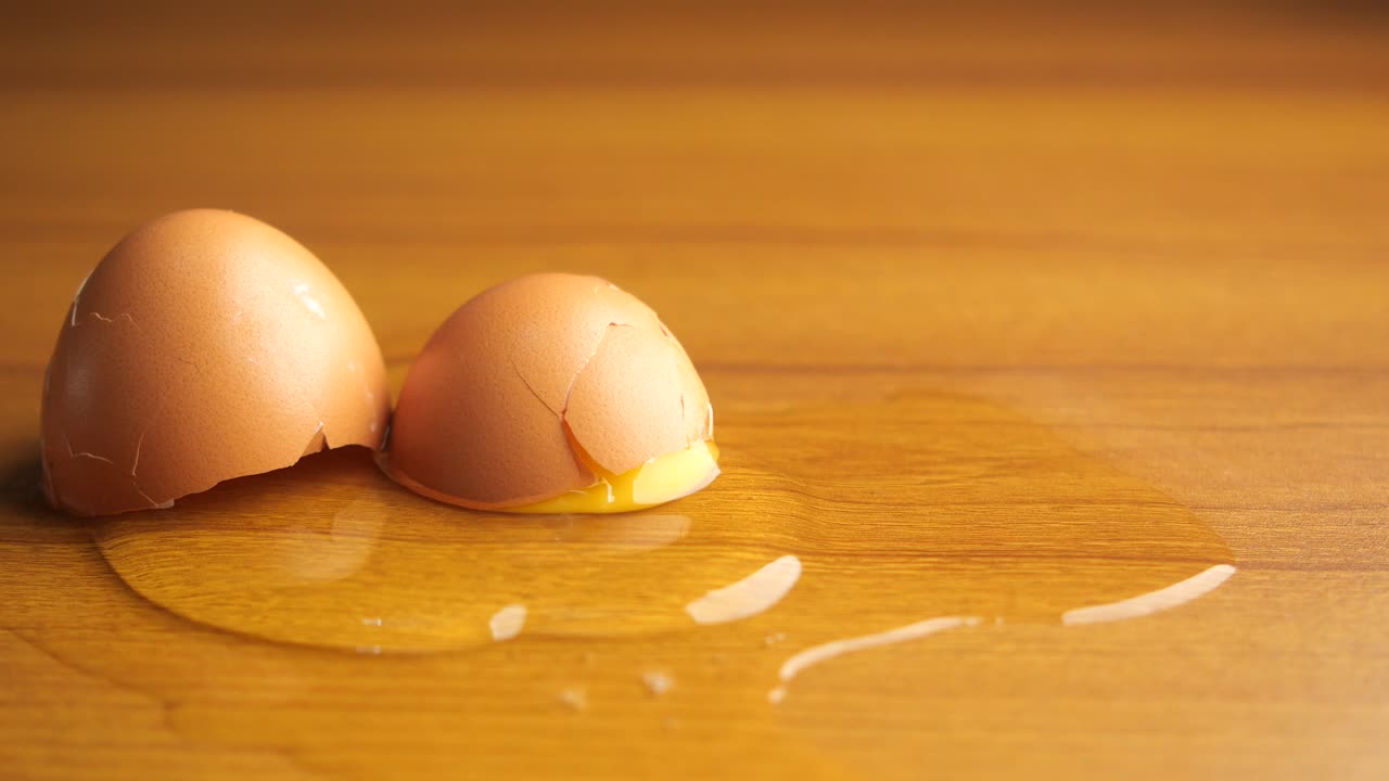A cracked egg on a wooden table