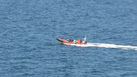 Hand-held-tracking-shot-of-a-RIb-boat-carrying-tourists-off-the-coast-of-Newquay