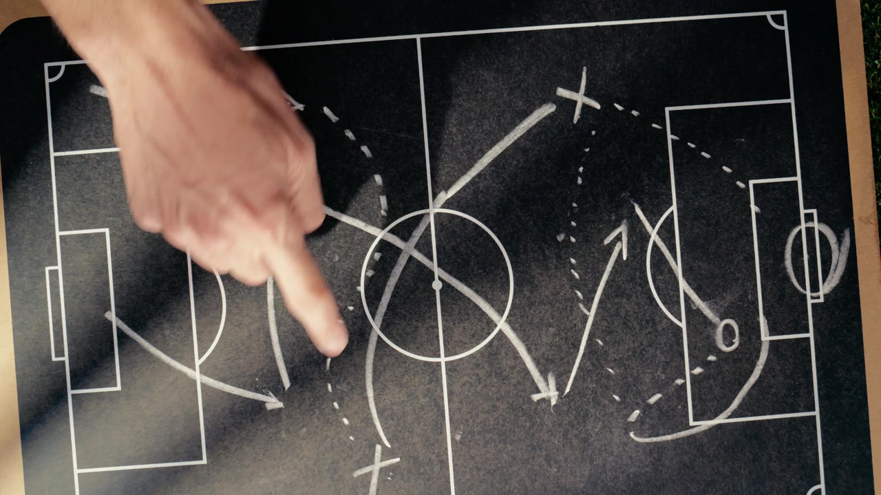 Soccer Coach Explaining Strategy on Tactical Chalkboard