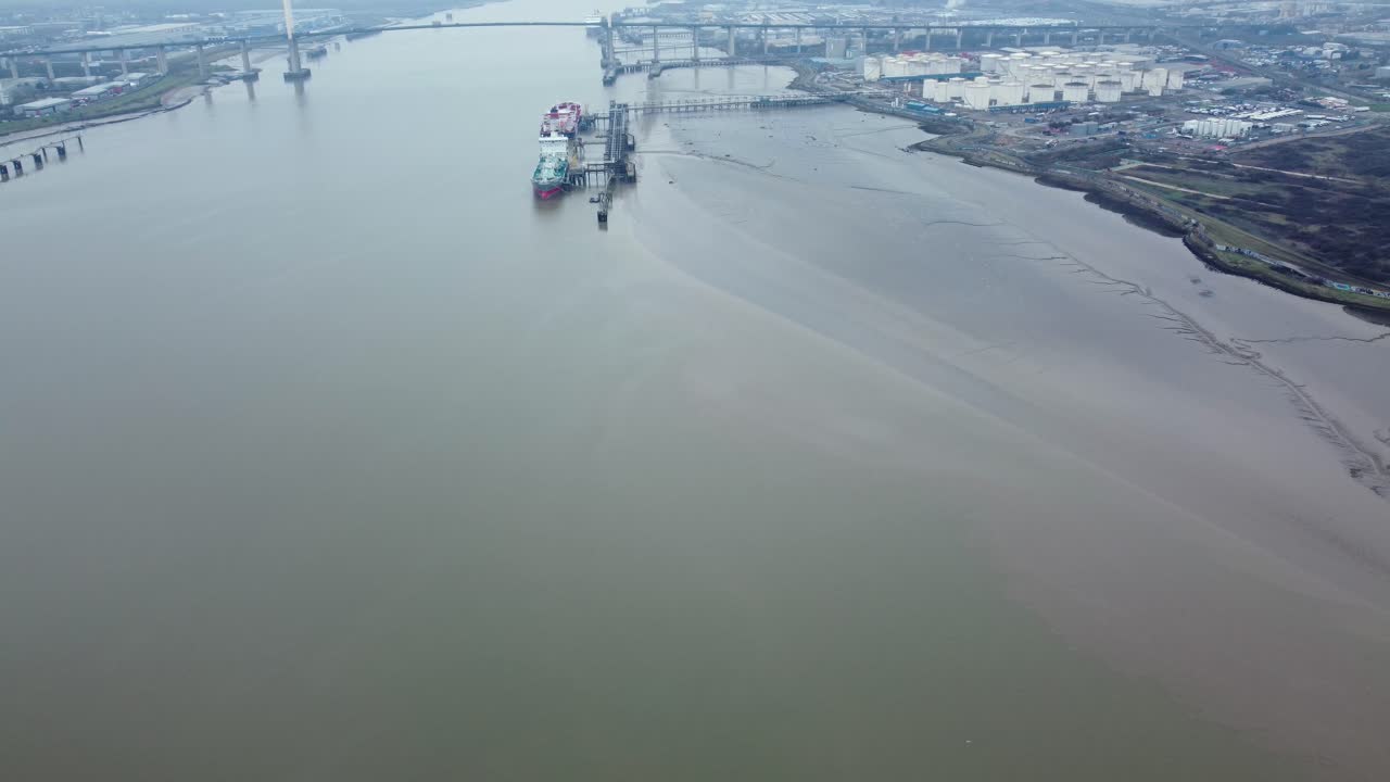 Aerial View of a River with a Ship, Bridge, and Industrial Area