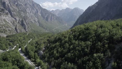 Drohnenvideo-Des-Flugzeugentdeckungsflugzeugs-Auf-Der-Straße-Azem-Hajdari-Zwischen-Den-Bergen-Auf-Der-Höhe-Des-Dorfes-Rragam-I-Shalese-Im-Valbona-Tal-Und-Dem-Fluss-Rrogam-I-Shales