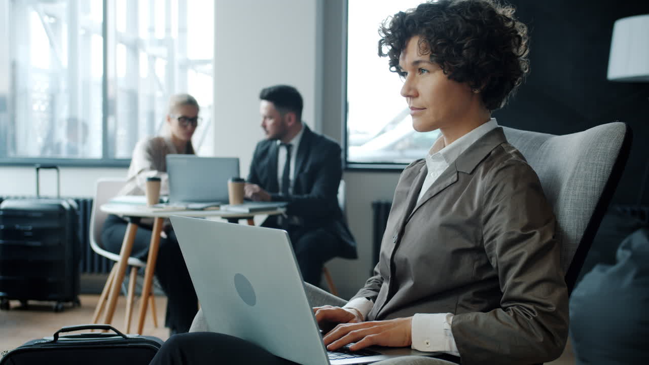 Businesswoman Working on Laptop in Airport Lounge