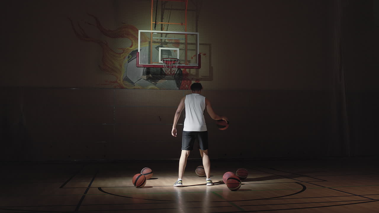 Sportsman Shooting Hoops on Dark Indoor Court