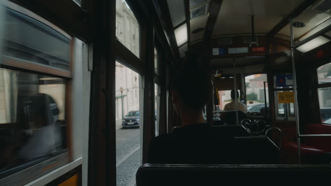 A person rides a tram through a city