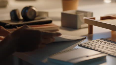 close up business woman hands paging documents reading information on project report working late in office at night