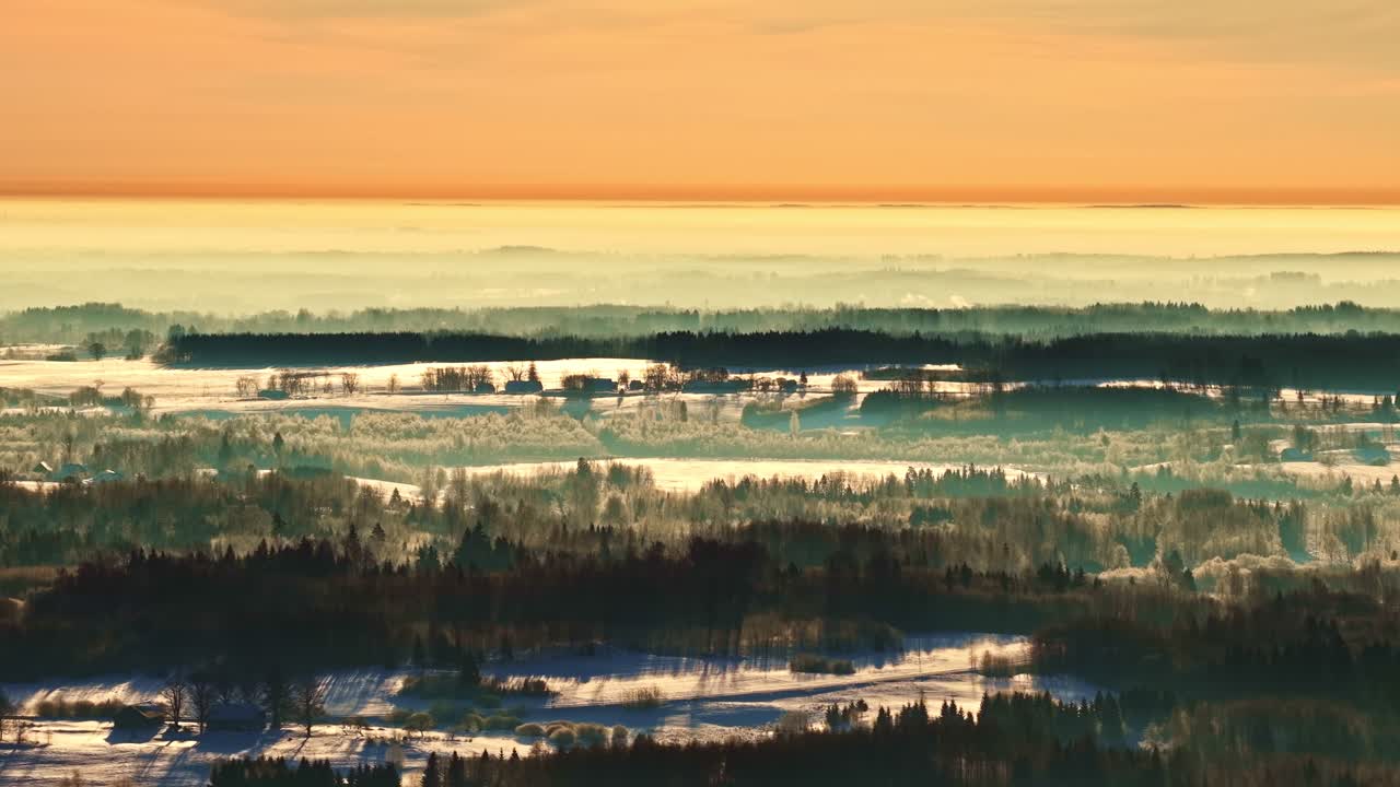 日の出の朝霧の中、ラトビアのラトガレ地方の雪に覆われた風景