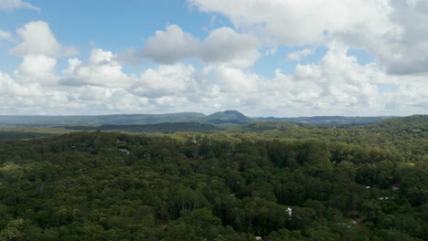 Australian-Bush-From-Above-With-Blue-Sky,-White-Clouds-And-Dark-Shadows-On-Treetops,-4K-Resolution-Drone