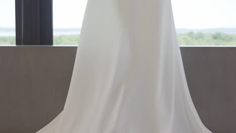 el vestido de novia cuelga sobre la cama.