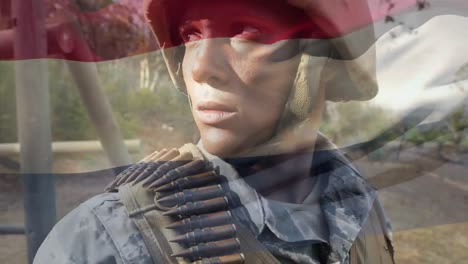 Digital-composition-of-waving-netherlands-flag-against-soldier-standing-at-training-camp