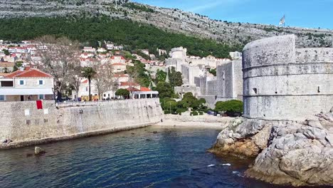 Dubrovnik-coastline,-rock-formations,-castle-walls,-mountain-background