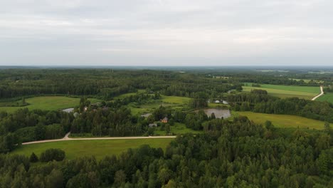 small town in countryside beside a lake surrounded with trees and farmlands, aerial