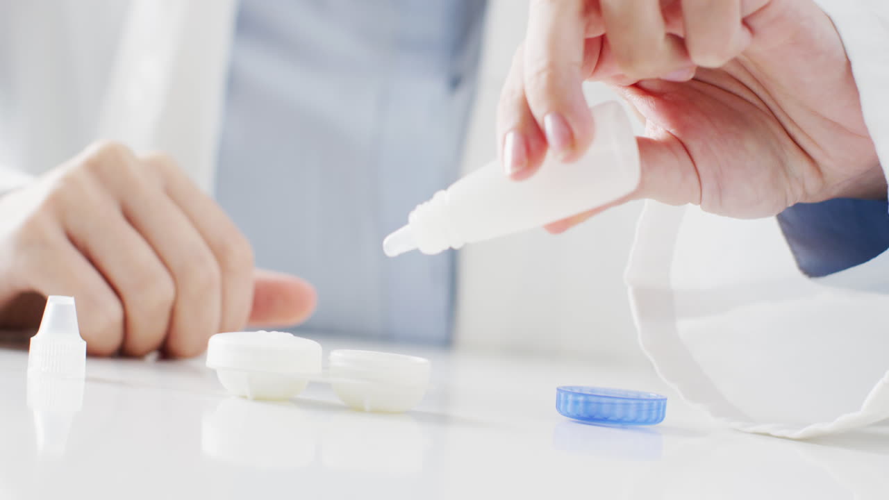 백인 의사가 콘택트 렌즈 케이스에 렌즈 용액을 넣는 중간 부분의 비디오