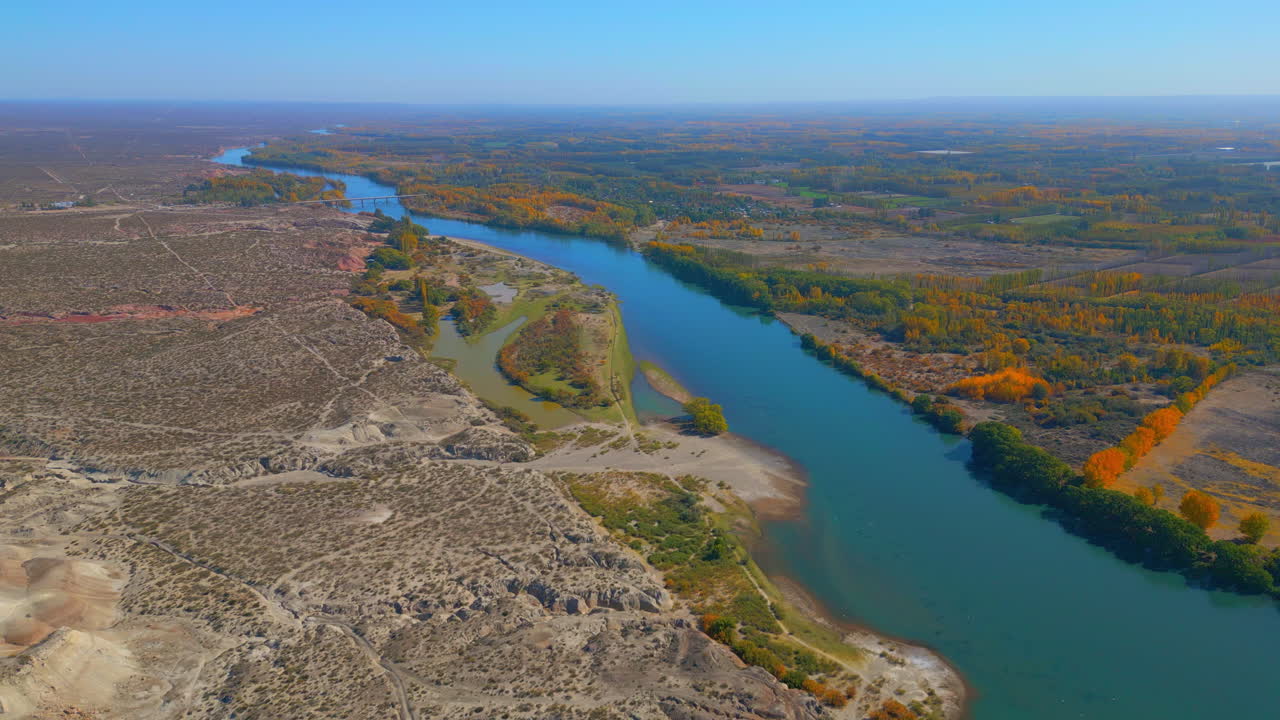Vista aérea de un río fluyendo a través de paisajes áridos y otoñales