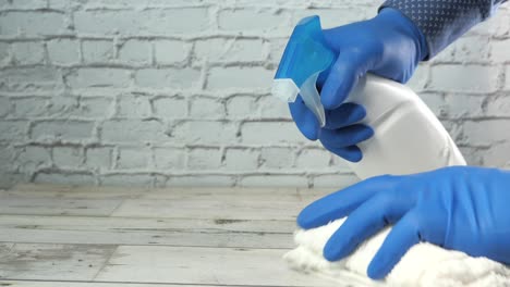 cleaning a wooden table with spray bottle and cloth