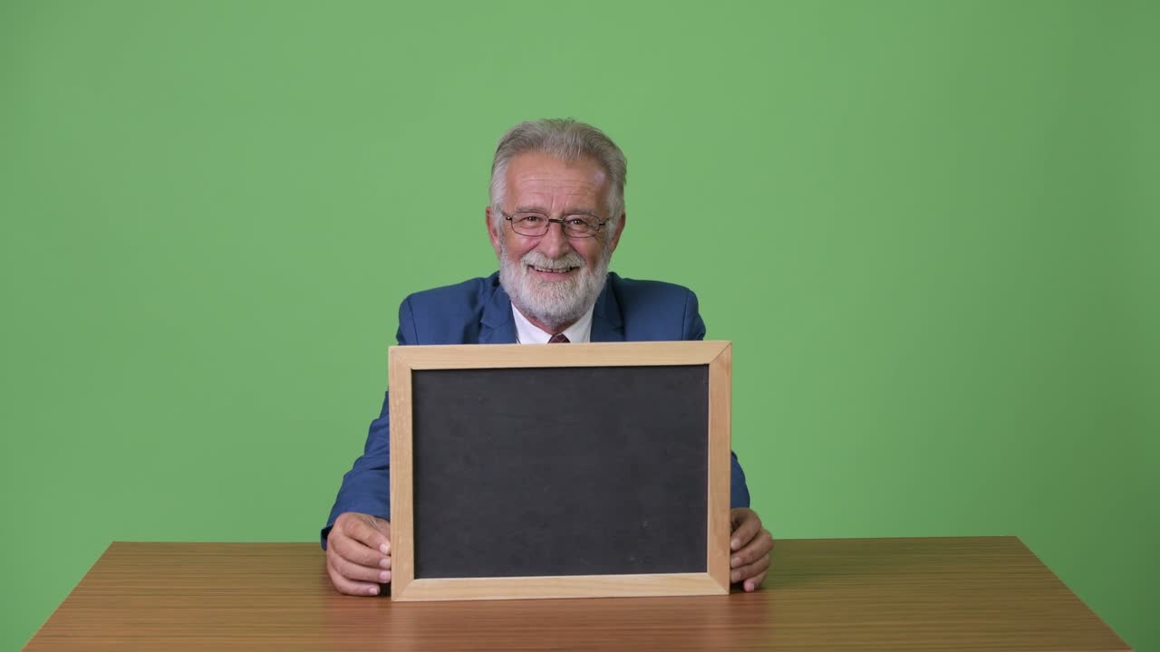 hombre de negocios barbudo y guapo contra un fondo verde.