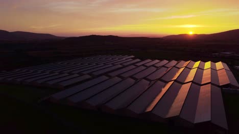 Erbauerantenne-Eines-Großen-Gewächshauses-Mit-Photovoltaik-Solarpaneelen,-Sonnenuntergang