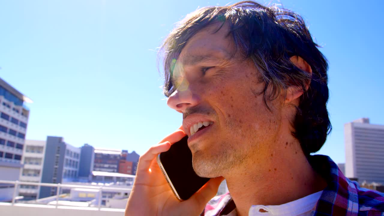 테라스 4k에서 휴대 전화로 이야기하는 남성 사진작가