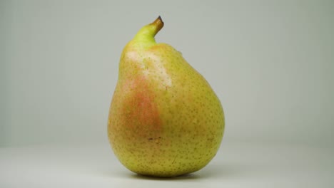 a heart shaped green pear moving on a turntable - close up shot