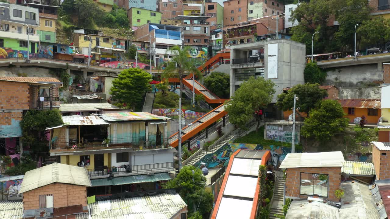 Drone recua para revelar o Bairro Comuna 13 com Escadas Rolantes Laranjas
