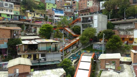 Dron-Vuela-Hacia-Atrás-Para-Revelar-El-Barrio-De-La-Comuna-13-Con-Escaleras-Mecánicas-Naranjas