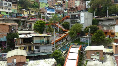 dron vuela hacia atrás para revelar el barrio de la comuna 13 con escaleras mecánicas naranjas