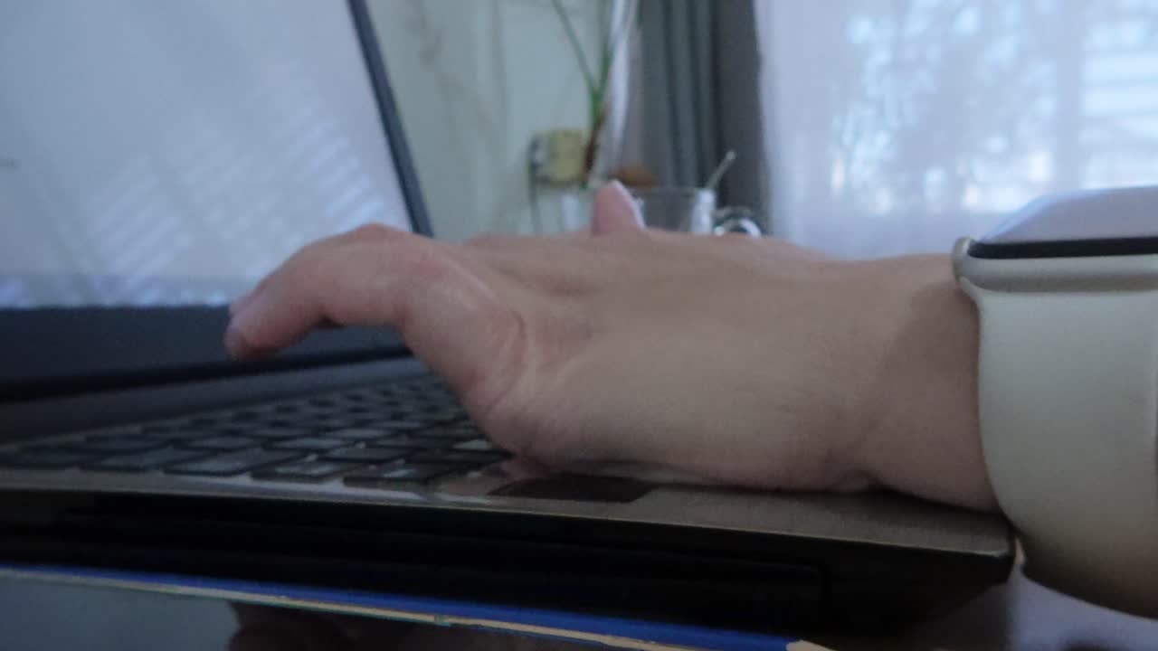 Side perspective of female hands typing an email or message on a laptop
