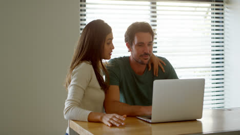 Couple-using-laptop-at-home-4k