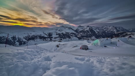 Time-lapse-of-snow-groomers-enjoying-Nine-Knights-event-on-snowcapped-mountains-under-cloudy-sky