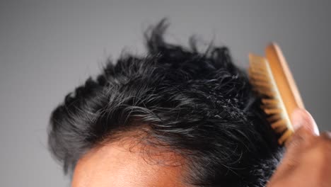 hombre cepillándose el cabello