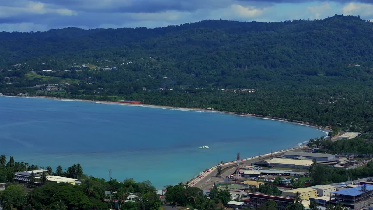 Wewak Hill Seawall Dogreto Bay shipwreck Boram road coastal town Meni Beach aerial drone Wewak East Sepik Region Province Papua New Guinea PNG summer sunny morning clouds dry season circle right