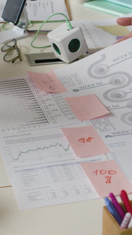 hands working on business documents and charts at an office desk
